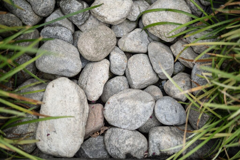 Smooth river stones laid along a grass lawn