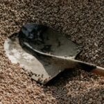 Shovel resting in a pile of landscaping gravel