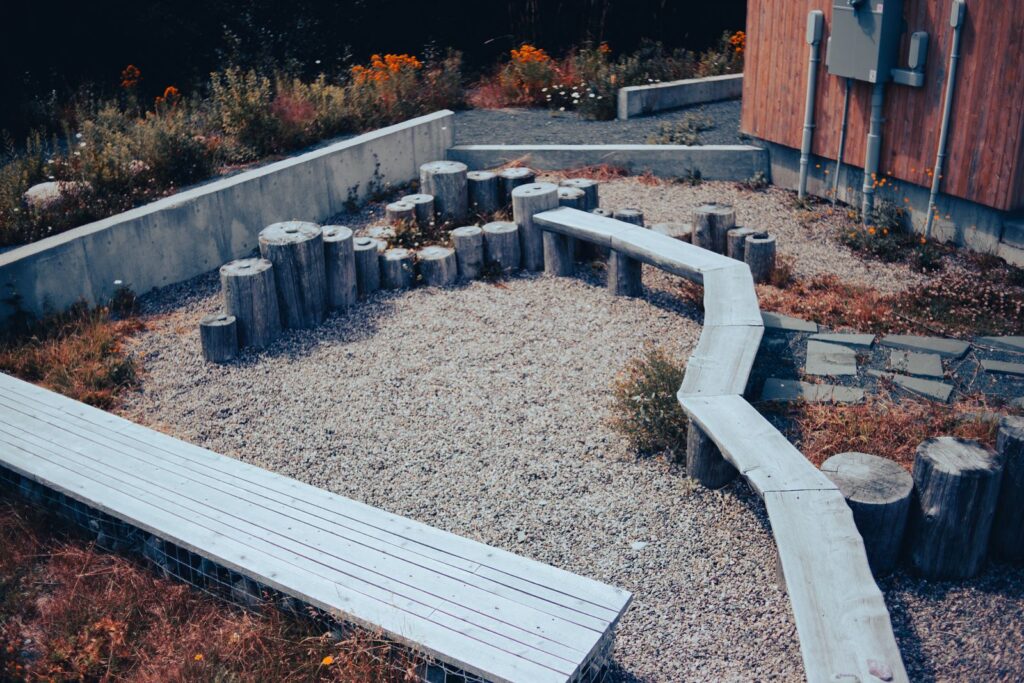 Benches and log seats on a backyard gravel patio
